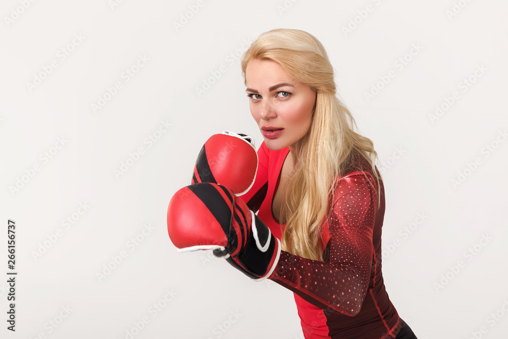 Portrait of young athlete blonde woman posing in boxing gloves isolated on gray background Portrait of young athlete blonde woman posing in boxing gloves isolated on gray background