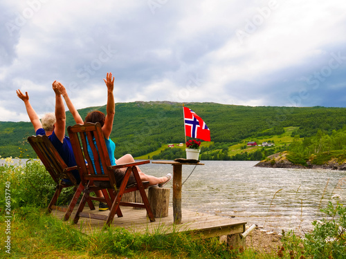 Couple relaxing on norwegian fjord shore