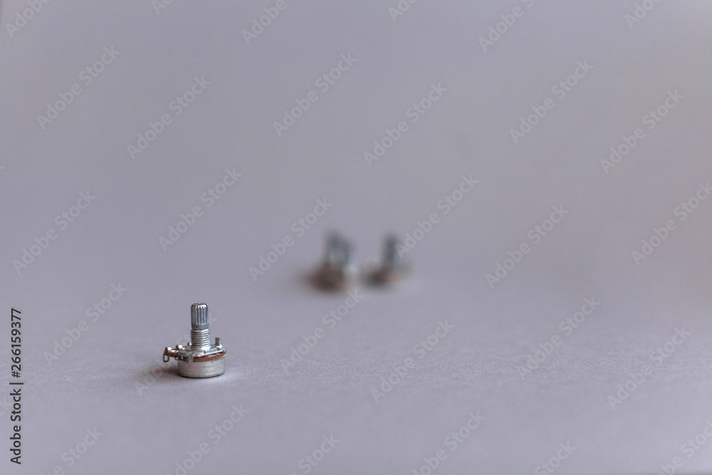 Potentiometers stand on the gray background. Many Potentiometers. Macro close up of electronic component potentiometer Potentiometers stand on the gray background. Many Potentiometers. Macro close up of electronic component potentiometer