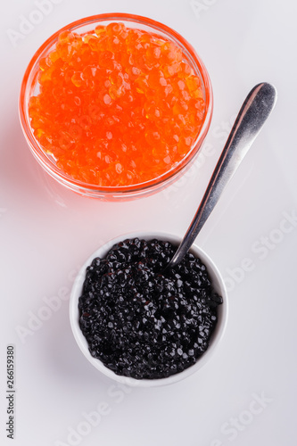 red and black caviar in a bowl on a white acrylic background