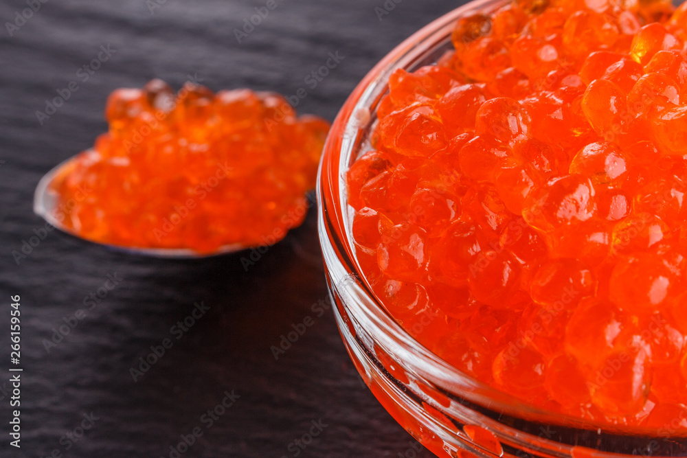 red caviar in a bowl on a dark stone background red caviar in a bowl on a dark stone background