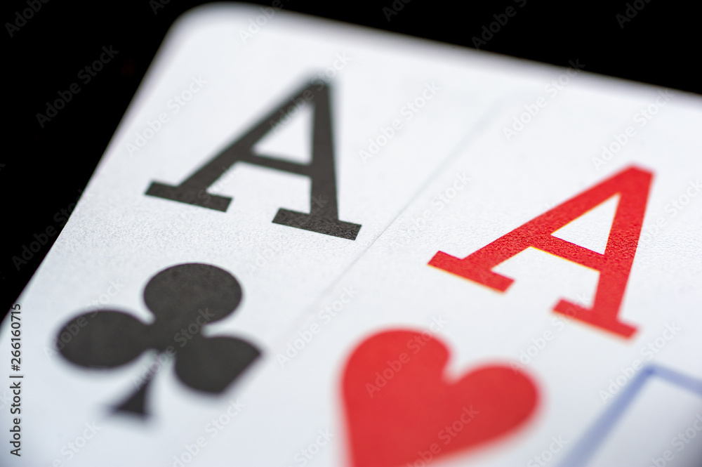 Two aces playing cards on black table