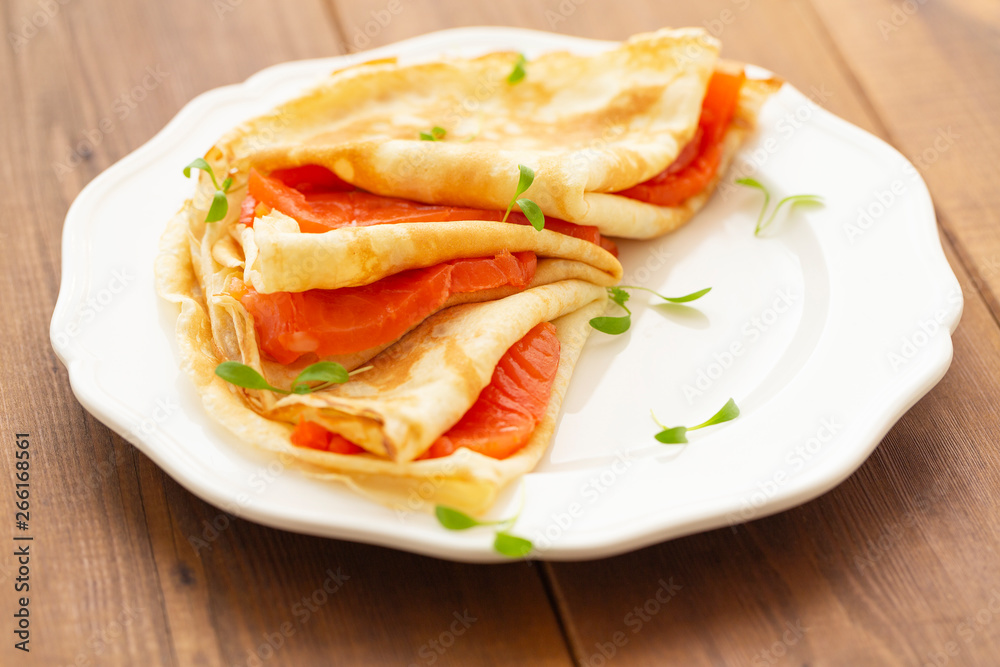 Crepes with smoked salmon on a white plate. Delicious and healthy Breakfast.