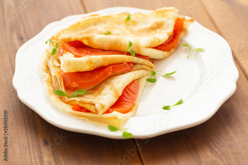 Crepes with smoked salmon on a white plate. Delicious and healthy Breakfast.