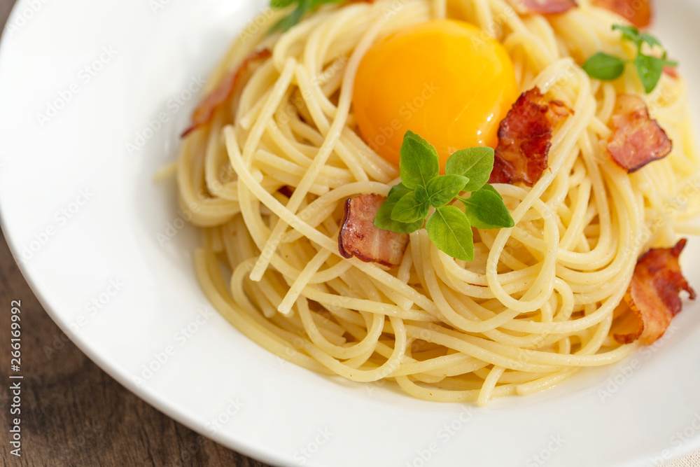 Carbonara pasta, spaghetti with pancetta, egg, hard parmesan cheese, basil and cream sauce. Traditional italian cuisine. 