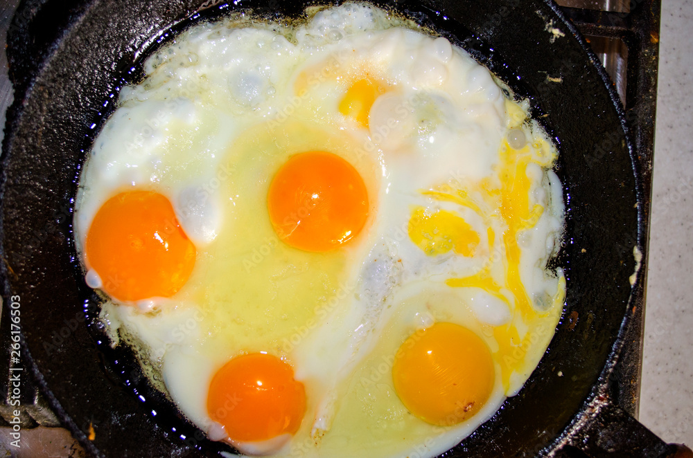 Appetizing fried five eggs cook in an old vintage cast iron skillet Appetizing fried five eggs cook in an old vintage cast iron skillet