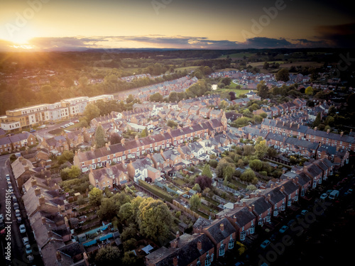 Sunset over traditional British houses with countryside in the background. A picturesque scene, created by the long shadows and warm glow