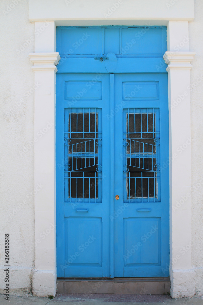 Blue front door in white stone wall