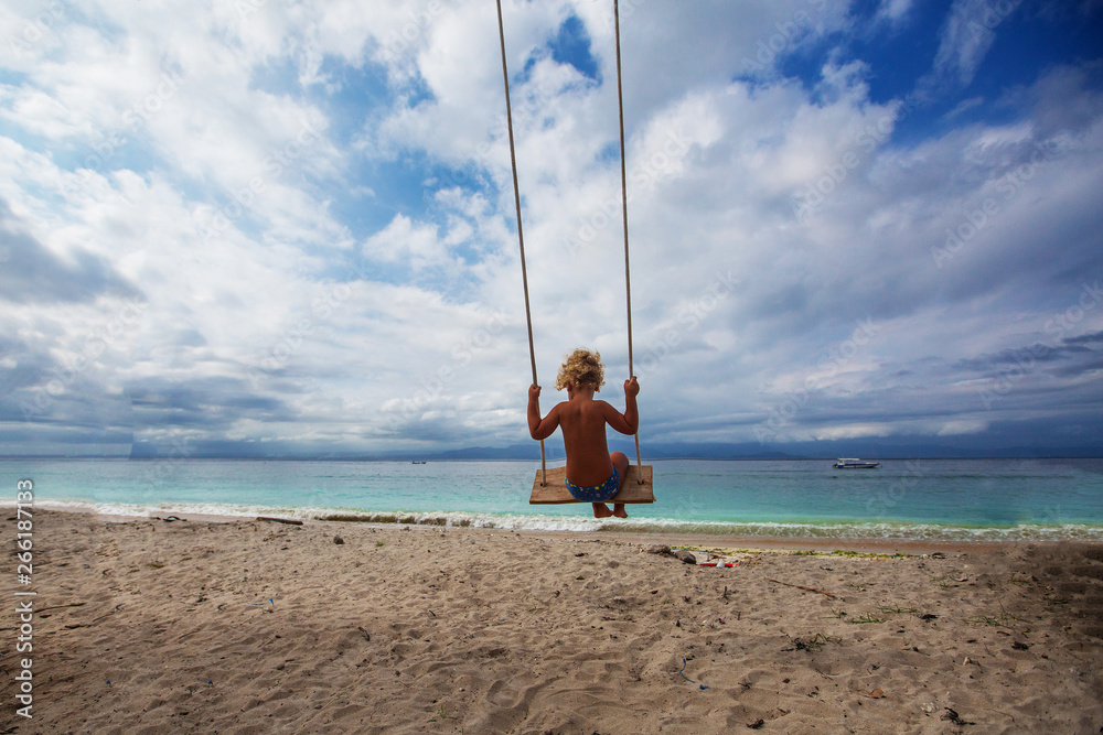 The back of the boys Swings are playing on the beach The back of the boys Swings are playing on the beach