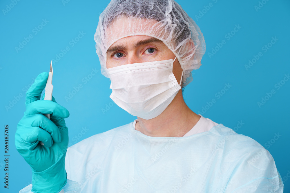 Surgeon in sterile blue uniform, medical gloves and mask Surgeon in sterile blue uniform, medical gloves and mask