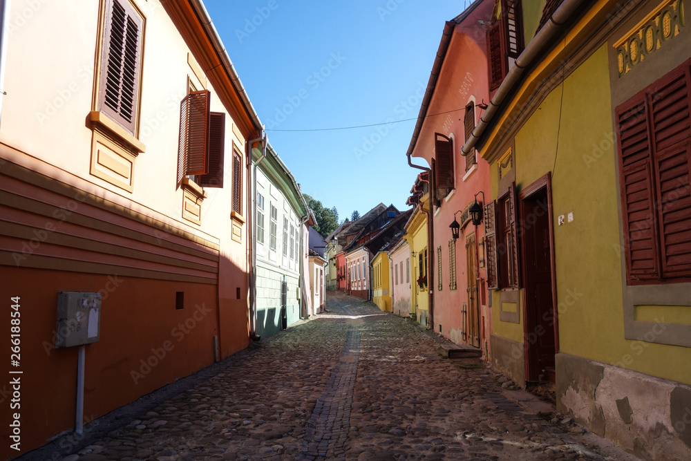 Colorful buildings in a narrow alley in Sighisoara (Sighișoara), Romania