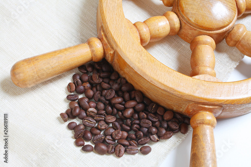 Coffee beans and the steering wheel on the background of burlap photo