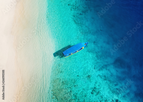 Boat on the water surface from top view. Turquoise water background from top view. Summer seascape from air. Gili Meno island, Indonesia. Travel - image photo