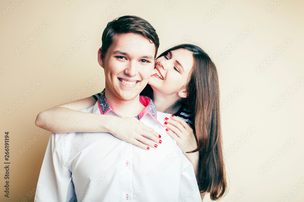 couple of happy smiling teenagers students, warm colors having a kiss, lifestyle people concept, boy and girl together close up