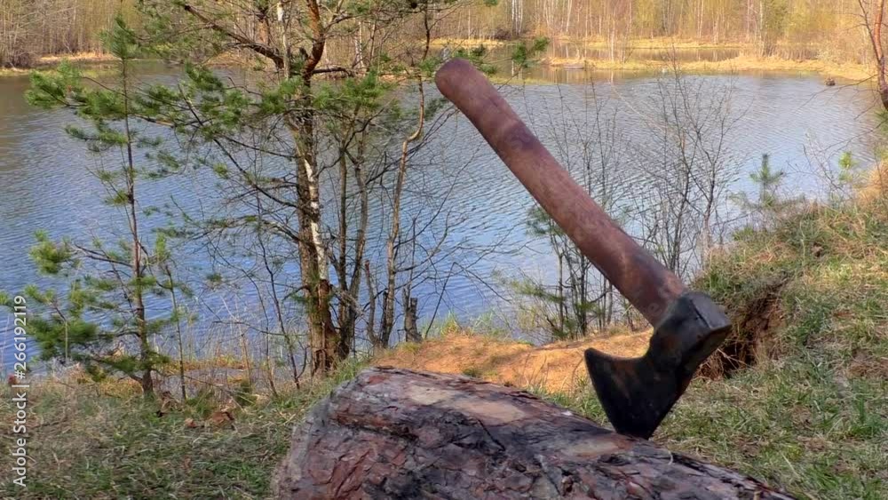 Scene with an ax in a tourist campsite. Camp tourists on the wild nature of northern Europe. Scene with an ax in a tourist campsite. Camp tourists on the wild nature of northern Europe.