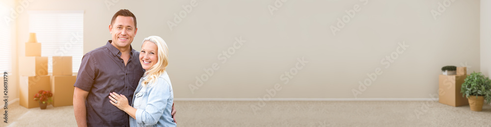 Happy Couple Inside Empty Room with Boxes Banner Happy Couple Inside Empty Room with Boxes Banner