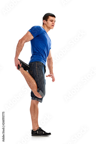 Full photo of young man stretching his legs before training