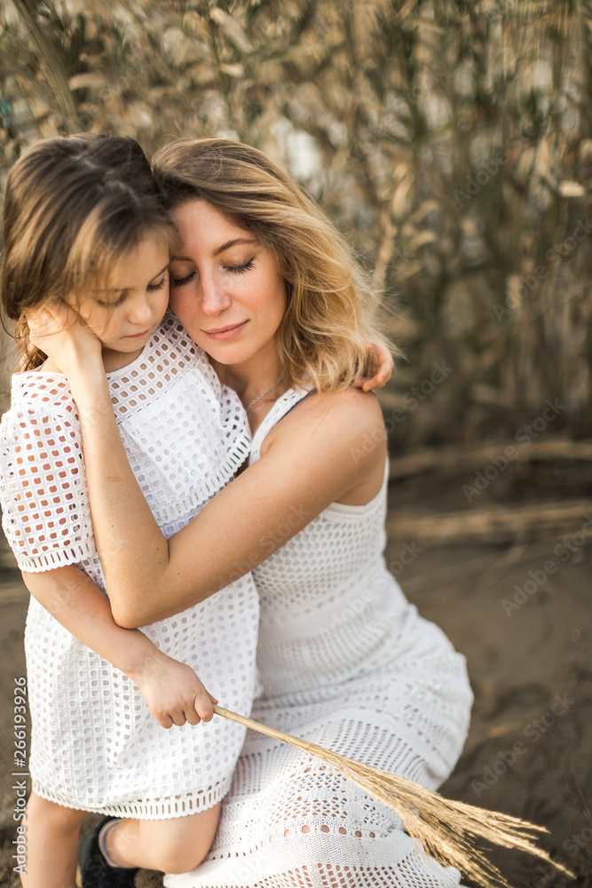 mother and daughter hugging in nature at summer