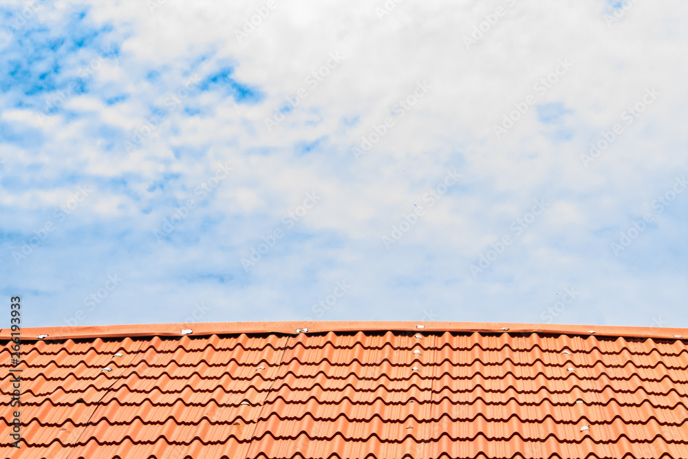 Red roof with a cloudy blue sky on top