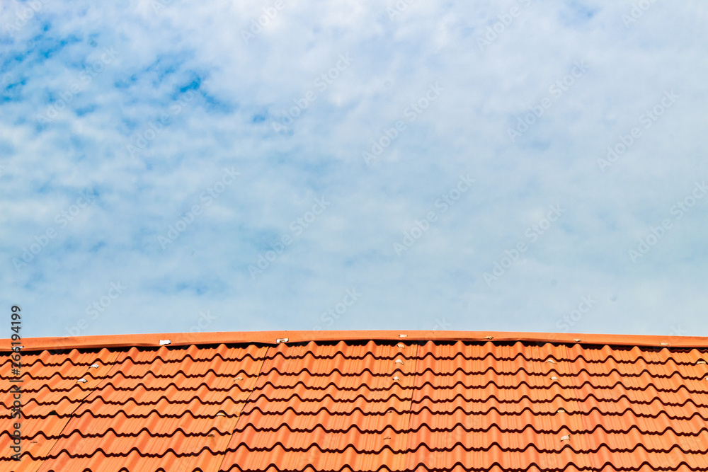 Red roof with a cloudy blue sky on top