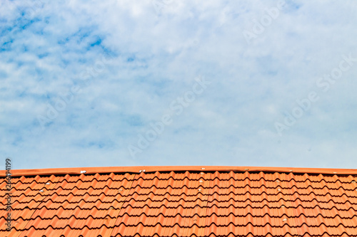 Red roof with a cloudy blue sky on top