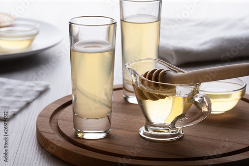 Fotografia honey and mead in a glass on a wooden stand