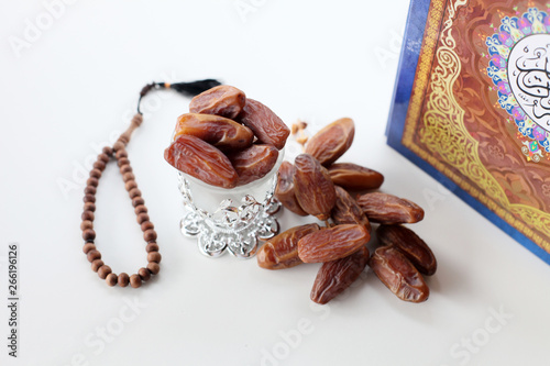 Ramadan kereem with holy quran, dates and rosary isolated on white background photo