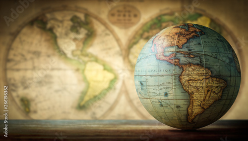 Old globe on vintage map background. Selective focus. Travel, stories and education background.