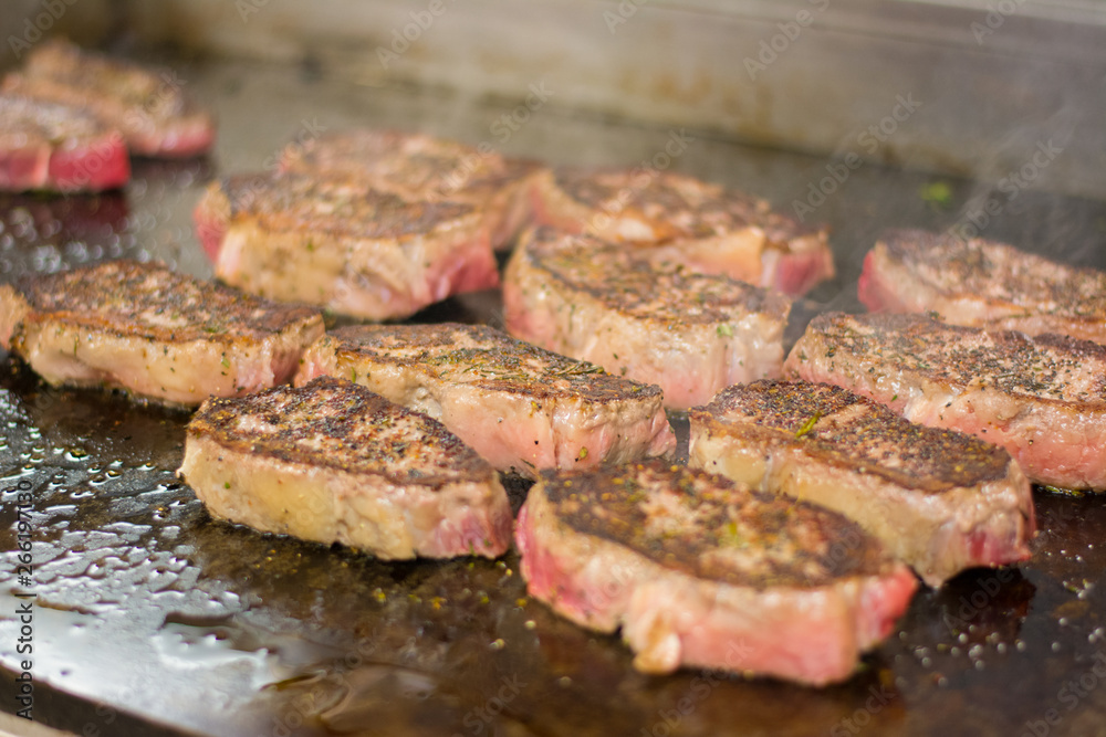 Steaks cooking on a flat top. Steaks cooking on a flat top.