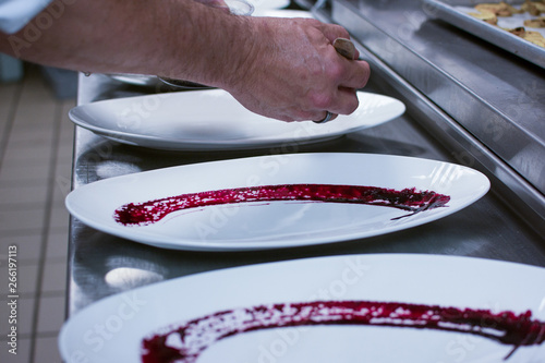 Chef adding sauce on a plate.   