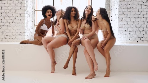 Group of multi ethnic women with different kind of beauty and body, posing and having fun in a studio photo