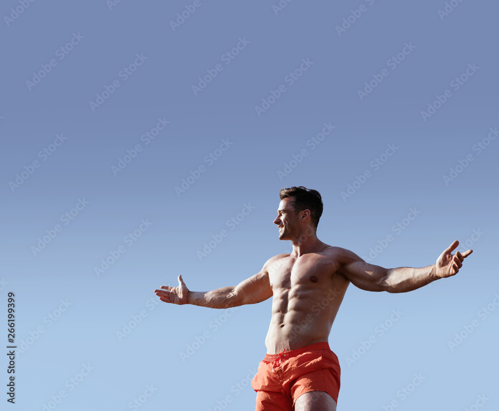 Obraz premium Portrait of a handsome, muscular man wearing red trunks