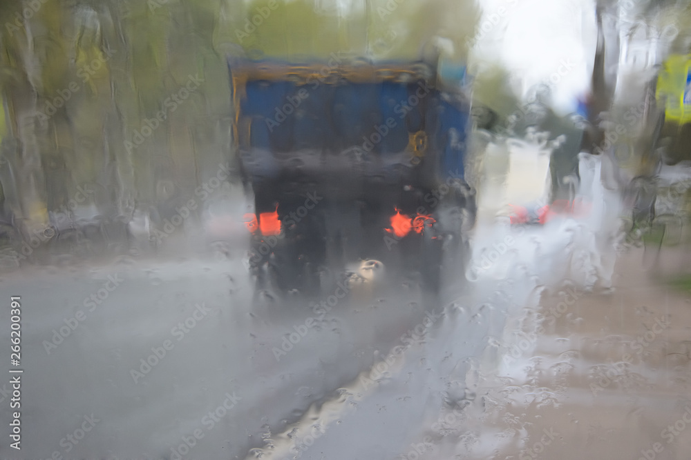 the vague image of the truck through the glass which is filled in with a rain