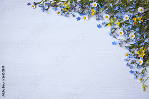 Spring flowers of forget-me-not, daisies and primroses on a wooden background