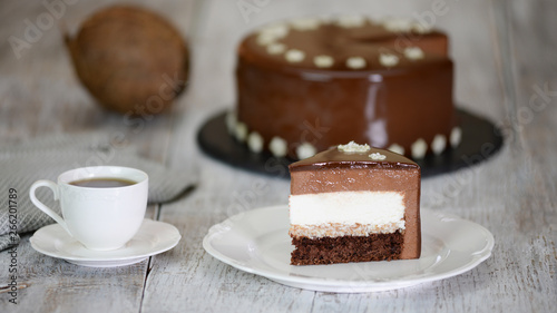 Piece of chocolate mousse cake with coconut filling on the old wooden background. Mousse cake with mirror glaze