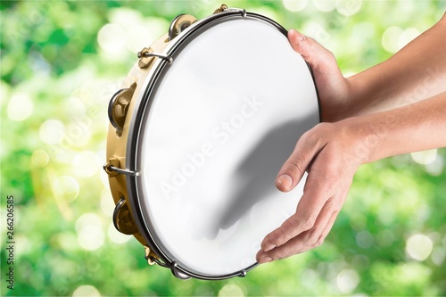 Photo Female hands Playing the tambourine on background