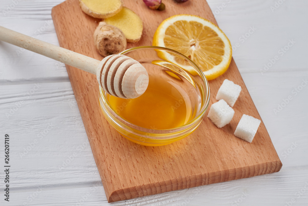 Honey with ginger and lemon on the cutting board. Best natural cold and flu recipe. Honey with ginger and lemon on the cutting board. Best natural cold and flu recipe.