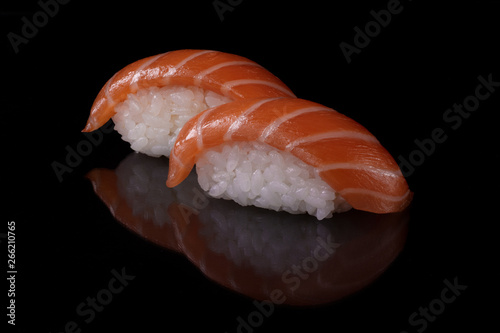 Close-up japanese food sushi with fresh salmon and rice on black background with reflection