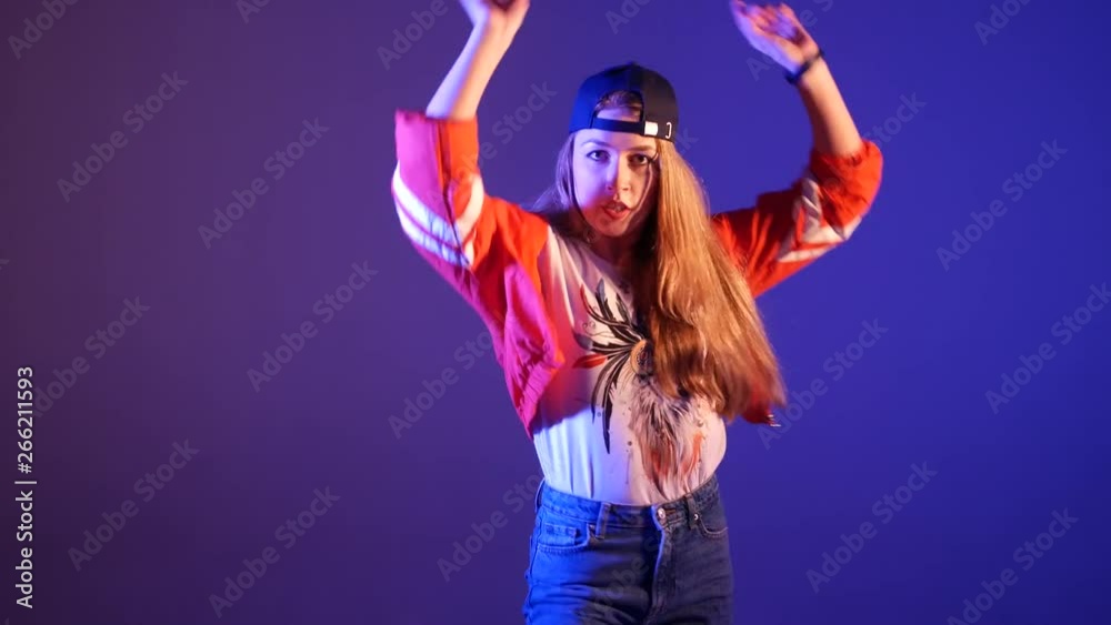 young beautiful girl in a baseball cap dancing hip hop, street dancing in the studio on a purple background, isolated young beautiful girl in a baseball cap dancing hip hop, street dancing in the studio on a purple background, isolated