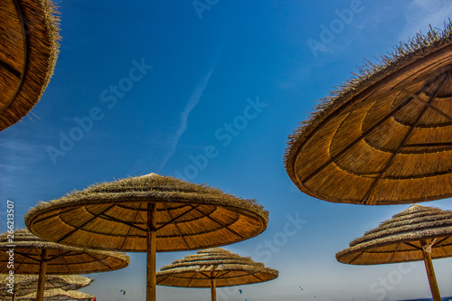 straw umbrellas beach outdoor scenic landscape on blue sky background  copy space 