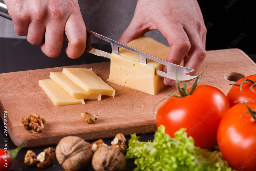 young woman slicing cheese in a gray apron young woman slicing cheese in a gray apron