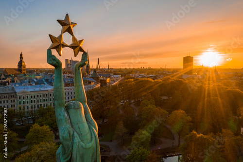 Beautiful sunset view over Riga by the statue of liberty - Milda in Latvia. The monument of freedom. People gathering around the monument for the concert.