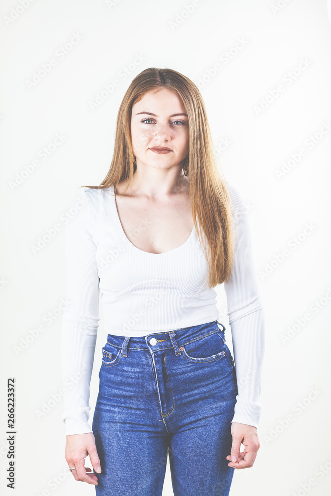 Frau, weißes Shirt und Jeans, brünette, lange Haare, schaut in die Kamera. Frau, weißes Shirt und Jeans, brünette, lange Haare, schaut in die Kamera.