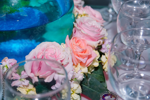 Close-up of bouquet of yellow, pink and coral roses. Cups around
