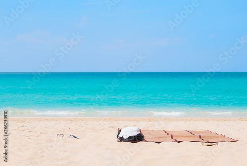 Fototapeta Naklejka Na Ścianę i Meble -  Summer vacation concept. Beach accessories on sand tropical beach. Sea view and blue sky background. Holiday - Image