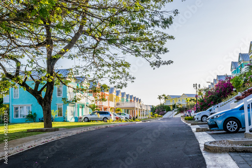 Residential neighborhood of colorful town houses/vacation homes. Upscale gated community residences in Caribbean island with manicured lawns, beautiful flowers and trees. photo