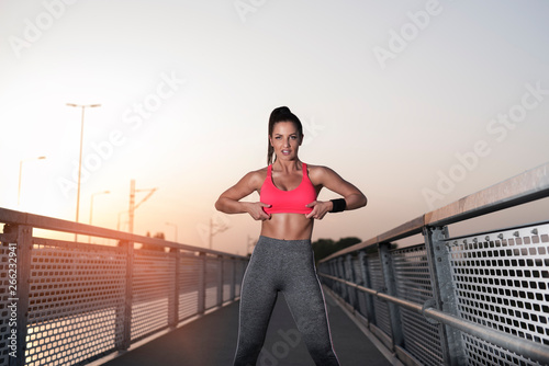 Amazing fit female athlete showing off, showing abs , outdoors portrait 