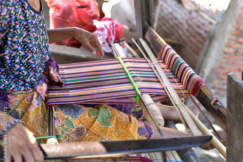 Hands of the Woman weaving on a loom in Sasak Village, Lombok, Indonesia photo