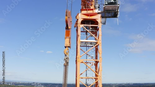 Hook, hoist rope or chains dangling from a tower crane on a residential construction site photo