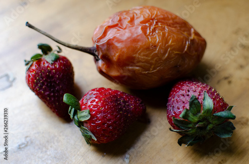 bodegón de tres fresas y un tomate de árbol en estado de sobre maduración